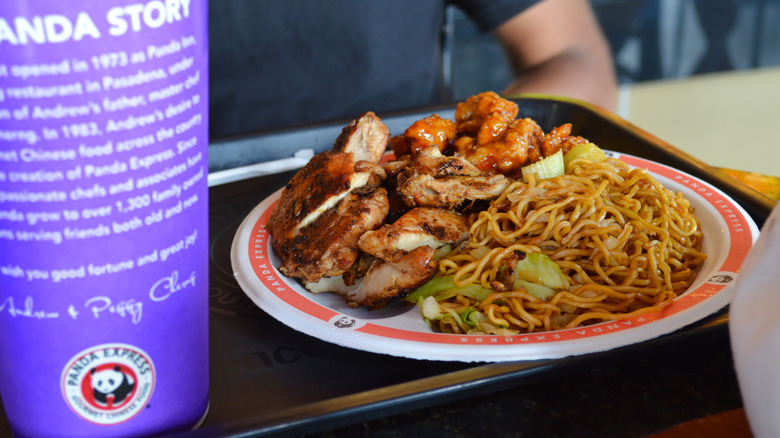 Panda Express food on plate and tray with drink.