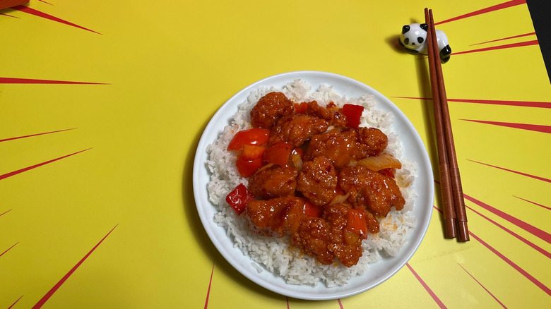A plate of Panda Express Dynamite Sweet and Sour Chicken with chop sticks
