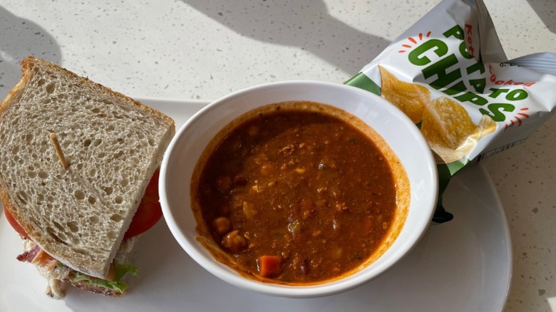 Panera half a sandwich, small bowl of chili, and a bag of potato chips