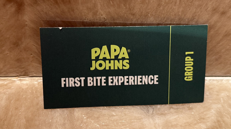 A Papa Johns meal ticket that says group one and first bite experience
