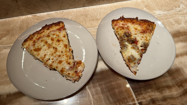 two different slices of Papa Johns Pan Pizza on plates, one plain cheese and the other sausage pepperoni, on marble counter