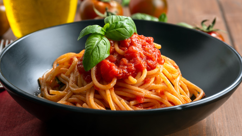 A dish of pasta with tomato sauce and fresh basil