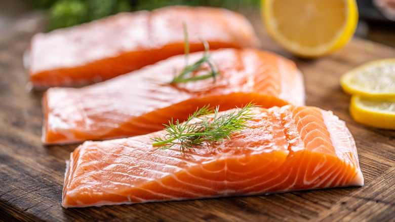 Raw salmon slices on cutting board