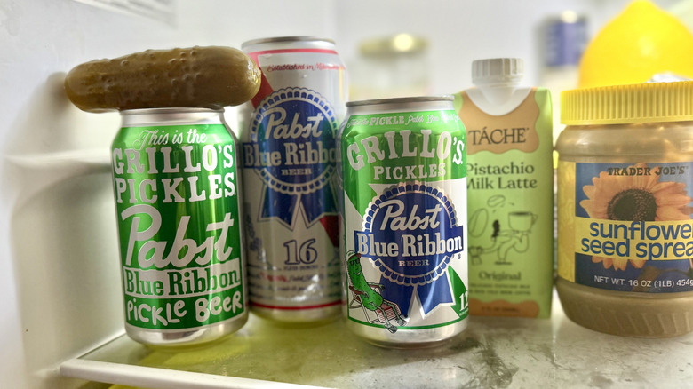 PBR x Grillo's Pickle Beer cans in a fridge, with an actual pickle