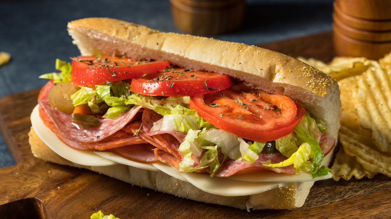 an Italian hoagie with cheese, meats, lettuce and tomato