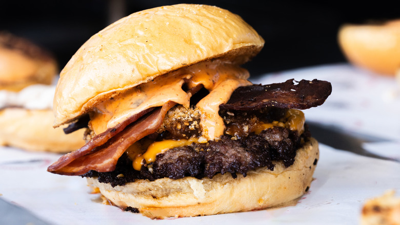 A cheeseburger on a bun with bacon and cheese