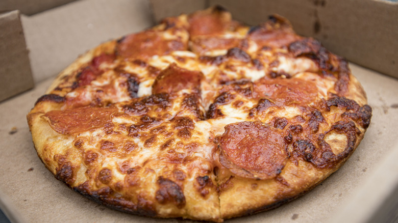Cheesy pepperoni pizza in a cardboard box