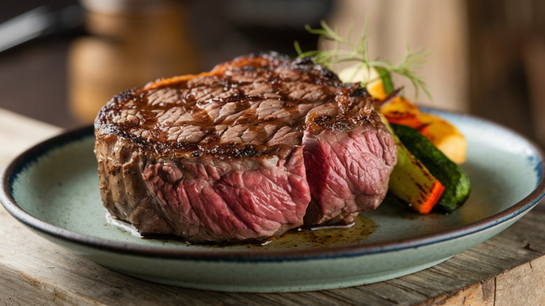 A thick rare seared steak on a plate