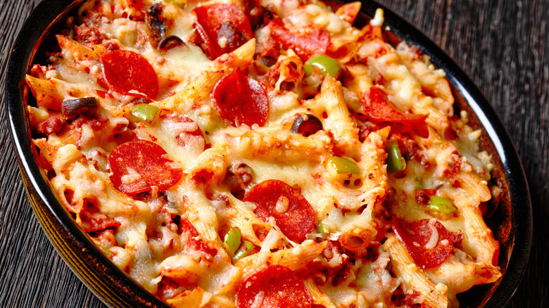 baked ziti with pepperoni and green peppers in a black pan