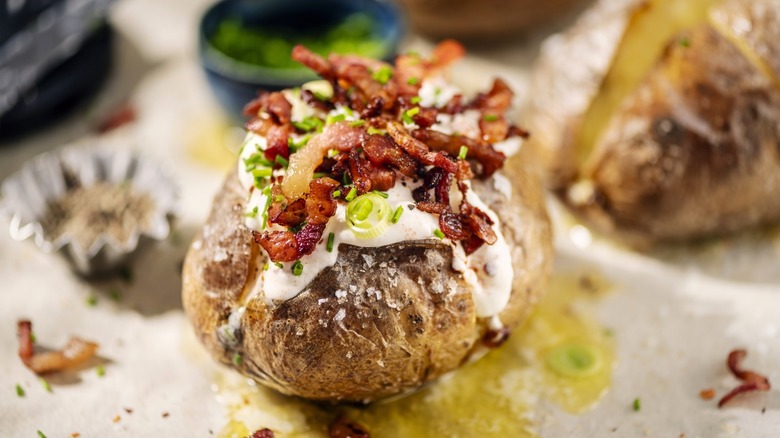 Loaded baked potato with sour cream, spring onions, and bacon bits