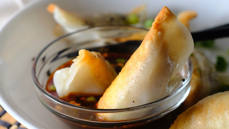 potstickers in a small glass dish of ponzu sauce