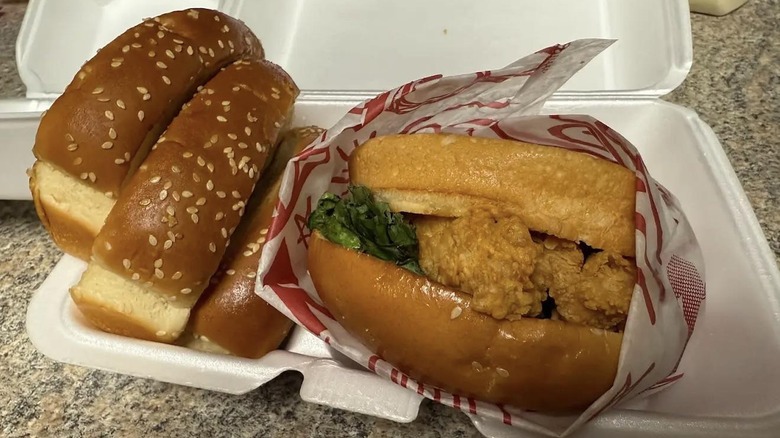 Fried chicken sandwich and pieces of toast from Raising Cane's in takeout container