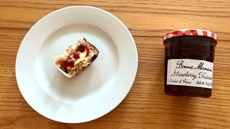 Bonne Maman strawberry preserves jar next to a piece of baguette