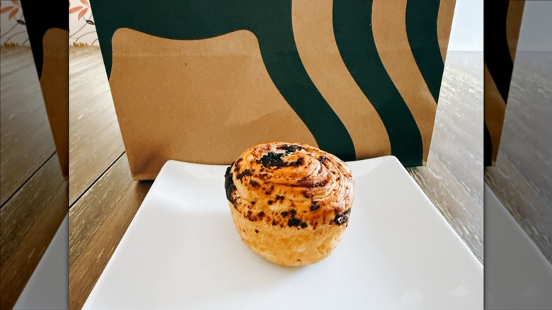 Starbucks cookie croissant swirl on a white plate with Starbucks bag in the background
