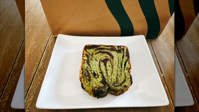 Starbucks Chocolate Pistachio Loaf on a white plate with Starbucks bag in the background