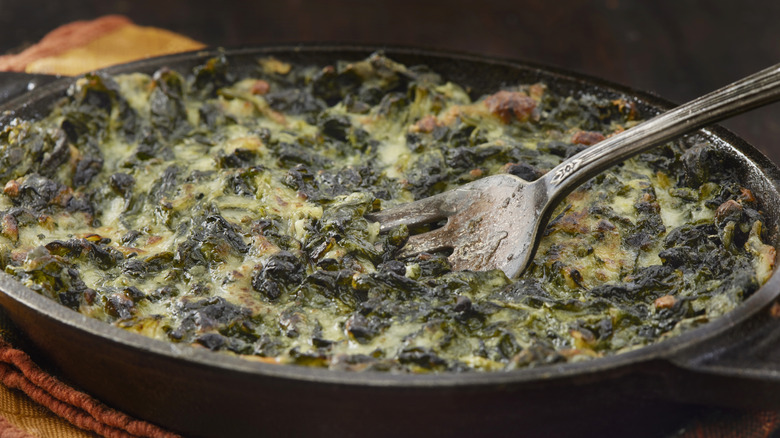 Dish of creamed spinach, with steel serving fork