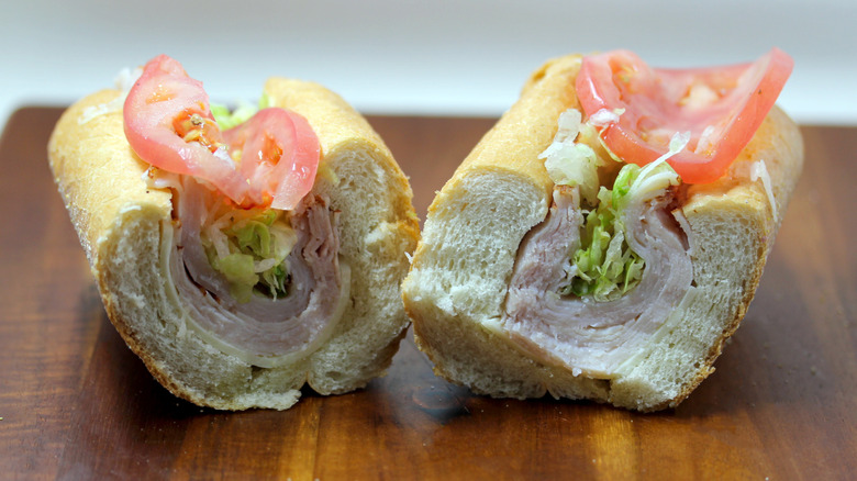 a turkey hoagie from Wawa split in half on a wooden surface