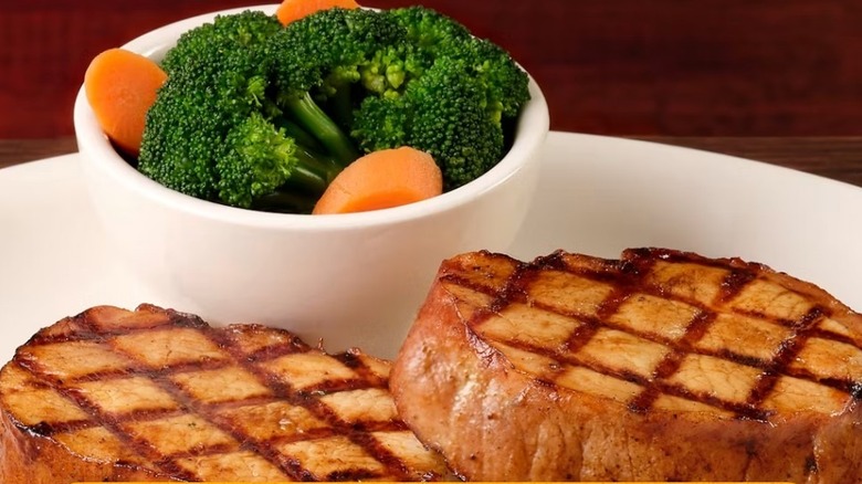 Texas Roadhouse pork chops with a side of broccoli and carrots
