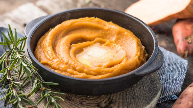 Bowl of mashed sweet potatoes with melted butter