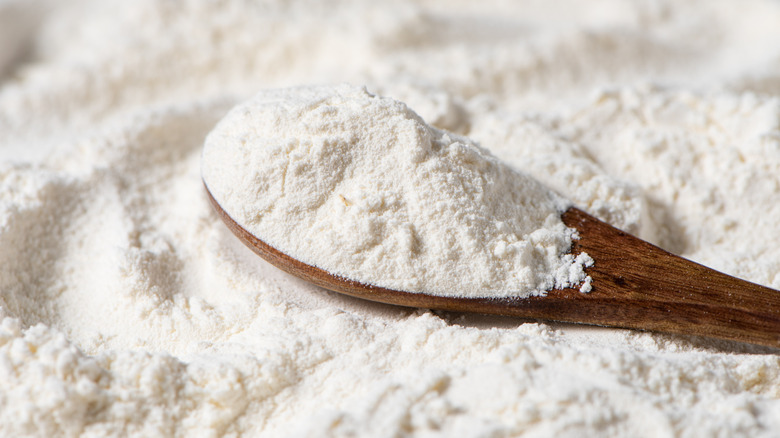 Close up of cake flour in a wooden spoon