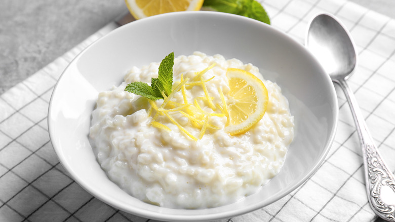 Bowl of rice pudding with lemon and mint sprig