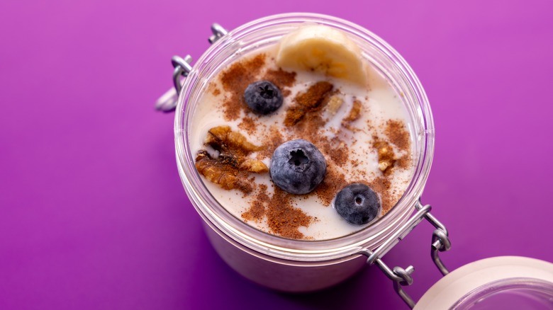 jar with overnight oats, banana, blueberries, walnuts, cinnamon