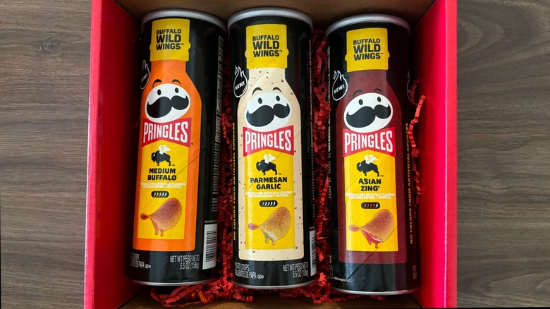 Pringles and Buffalo Wild Wings chip tubes in red box on wooden table