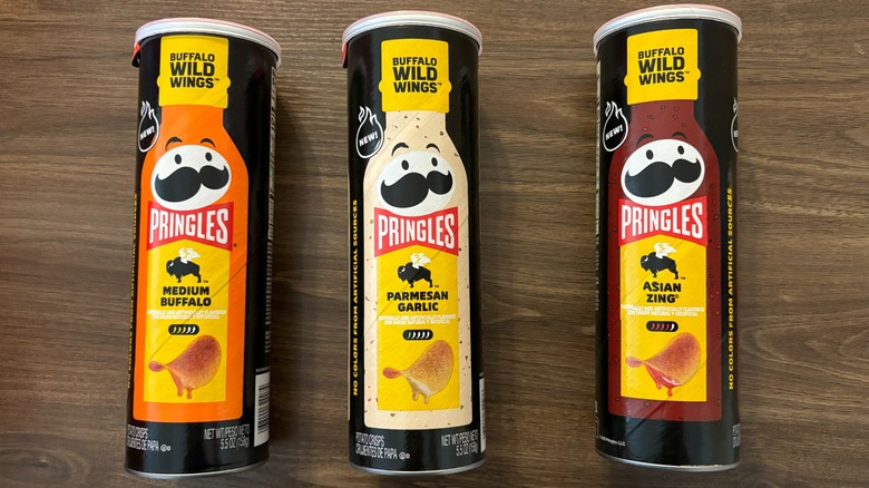 three tubes of Buffalo Wild Wings Pringles unopened on wooden table