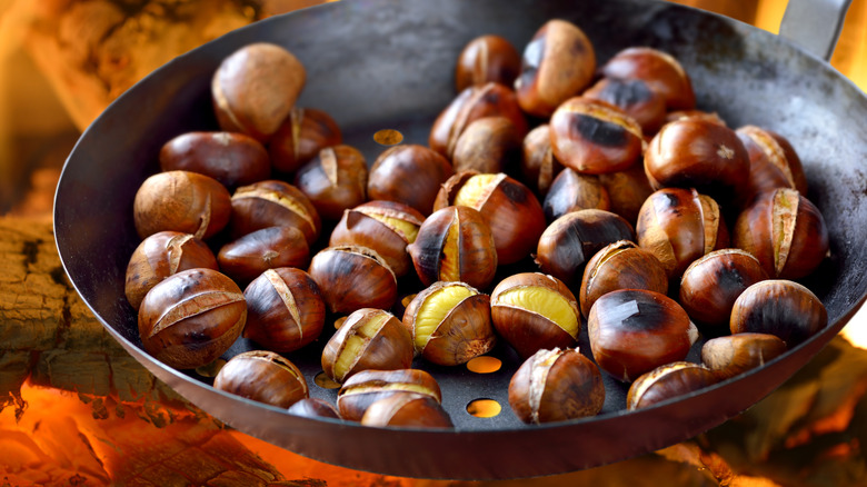 chestnuts roasting in a pan over an open flame