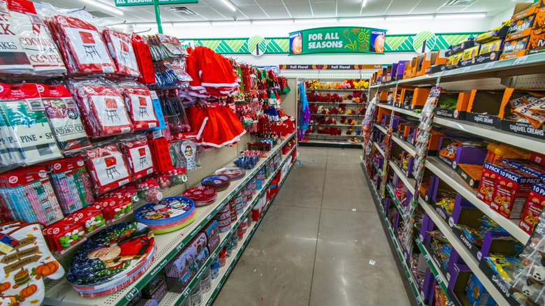 A view down a holiday aisle in a dollar tree with Christmas decorations visible