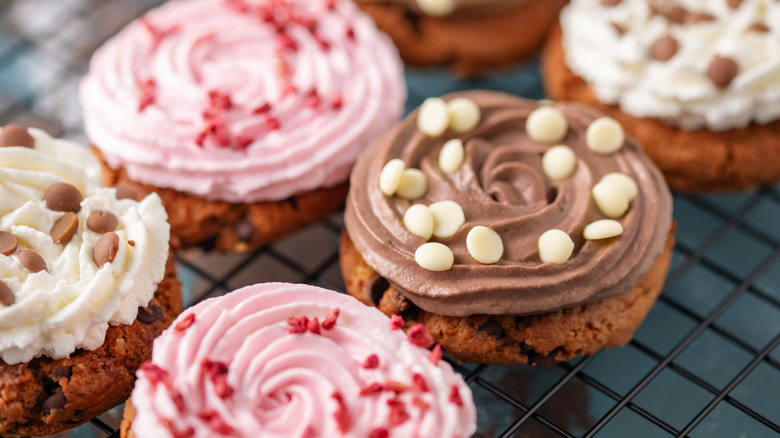 A wire rack holding an assortment of Crumbl cookies.