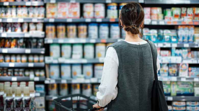A woman decides what to buy at grocery store