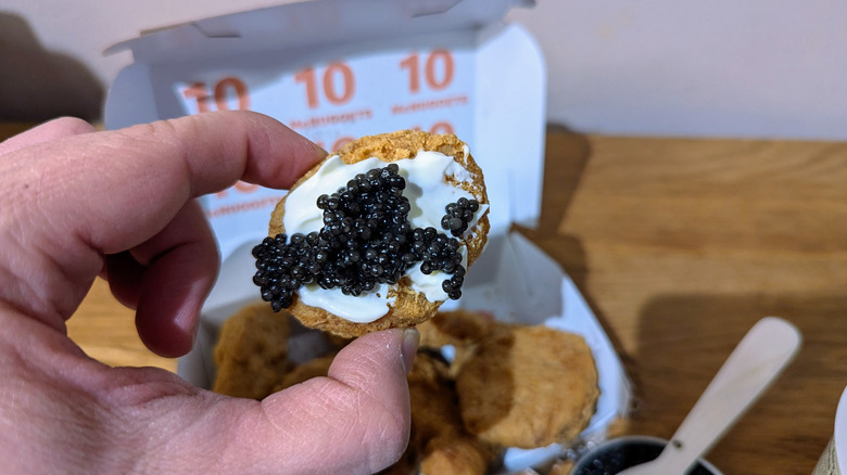 hand holding mcnugget with caviar