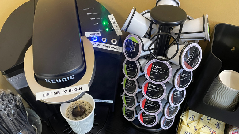 Keurig machine brewing coffee into disposable cup