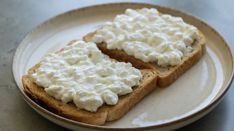 Cottage cheese spread on two slices of toast on a plate.