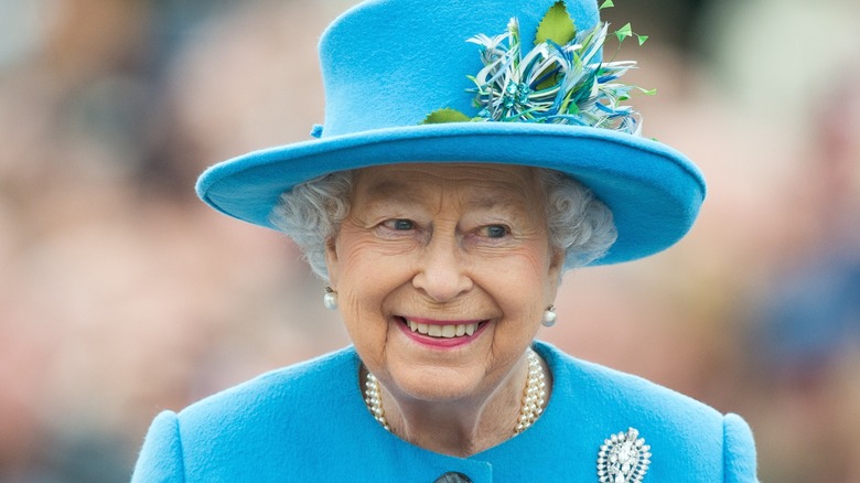Queen Elizabeth II wearing a blue dress and hat