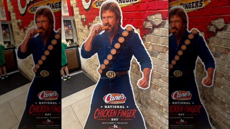 Ai-generated Chuck Norris cardboard cutout advertisement sitting in a Raising Cane's restaurant.