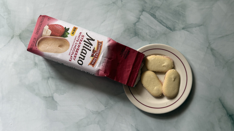 Milano Strawberry White Chocolate cookies on a plate beside the bag