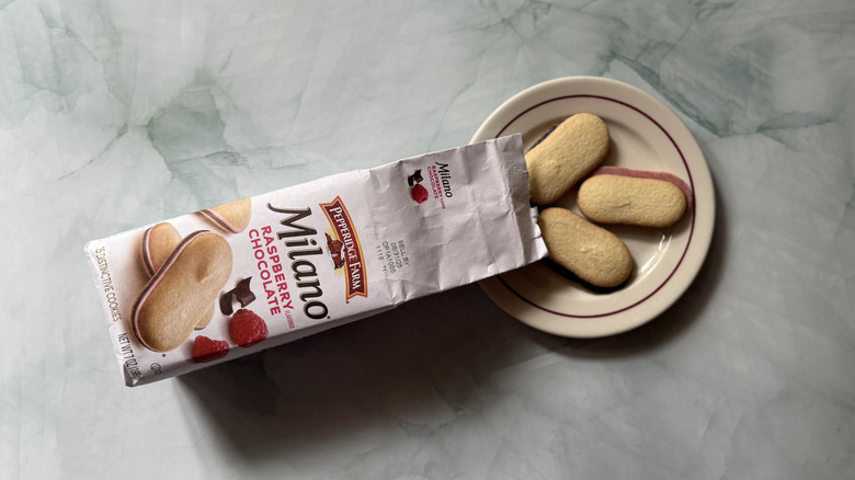 Milano Raspberry Chocolate cookies on a plate beside the bag