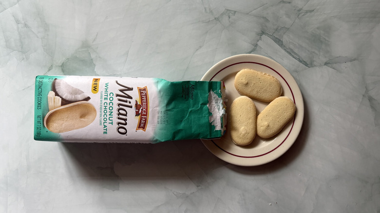 Milano Coconut White Chocolate cookies on a plate beside the bag