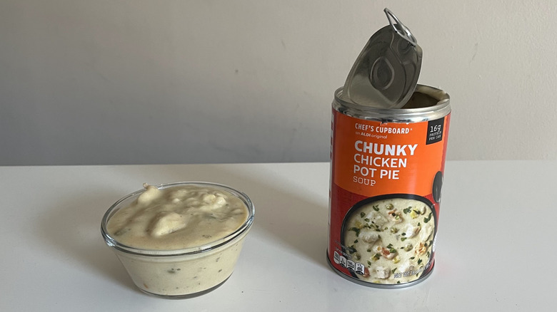 A can and bowl of chicken pot pie soup sit on a counter
