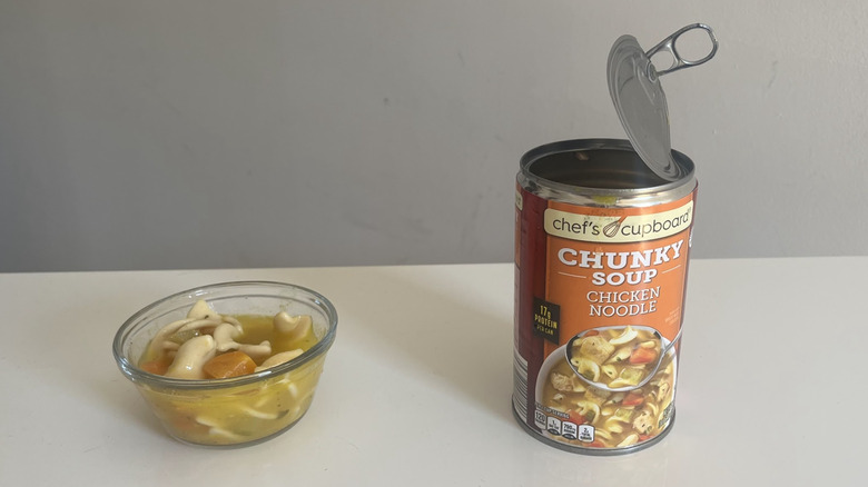 A bowl was pours of chunky chicken noodle soup