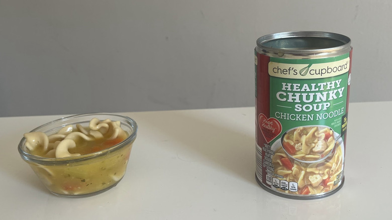 A can sits next to a bowl of Chef's Cupboard Healthy Chicken Noodle Soup
