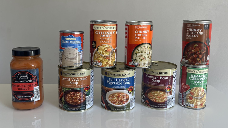 Nine cans of Aldi soups on a white counter