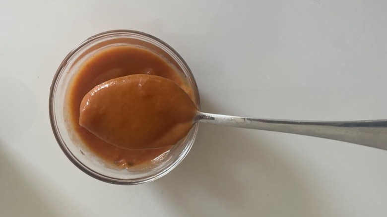 A spoonful lifted from a bowl of tomato bisque