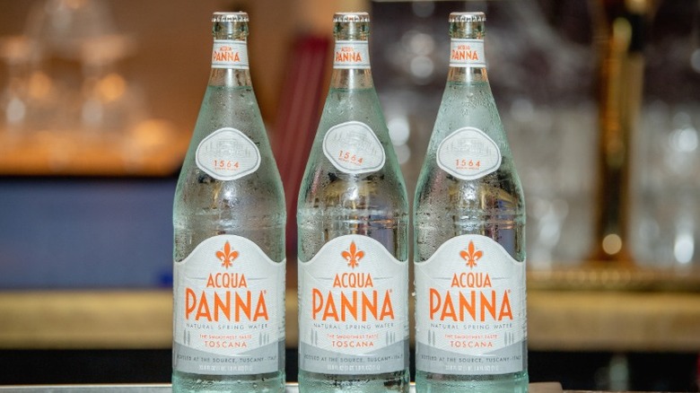 Three glass bottles of Acqua Panna water.