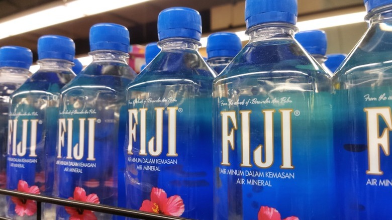 Bottles of Fiji water on a shelf.