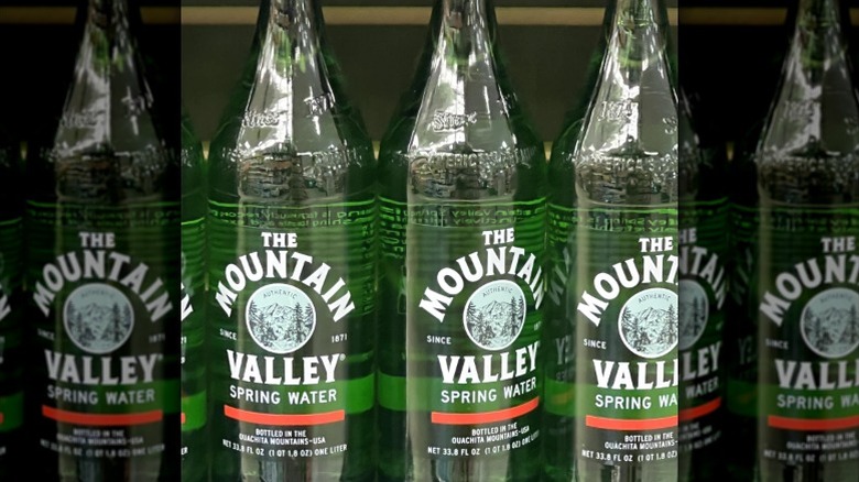 Bottles of Mountain Valley spring water on a shelf.