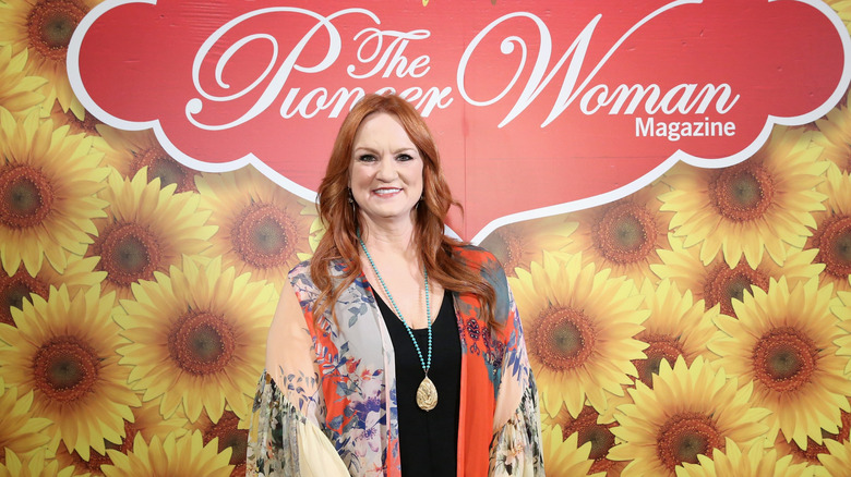 Ree Drummond smiling, standing in front of The Pioneer Woman magazine sign