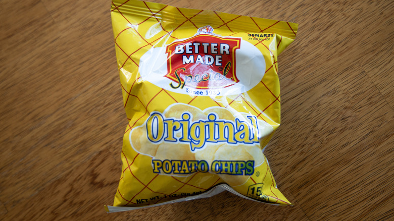yellow bag of Better Made potato chips on wooden surface
